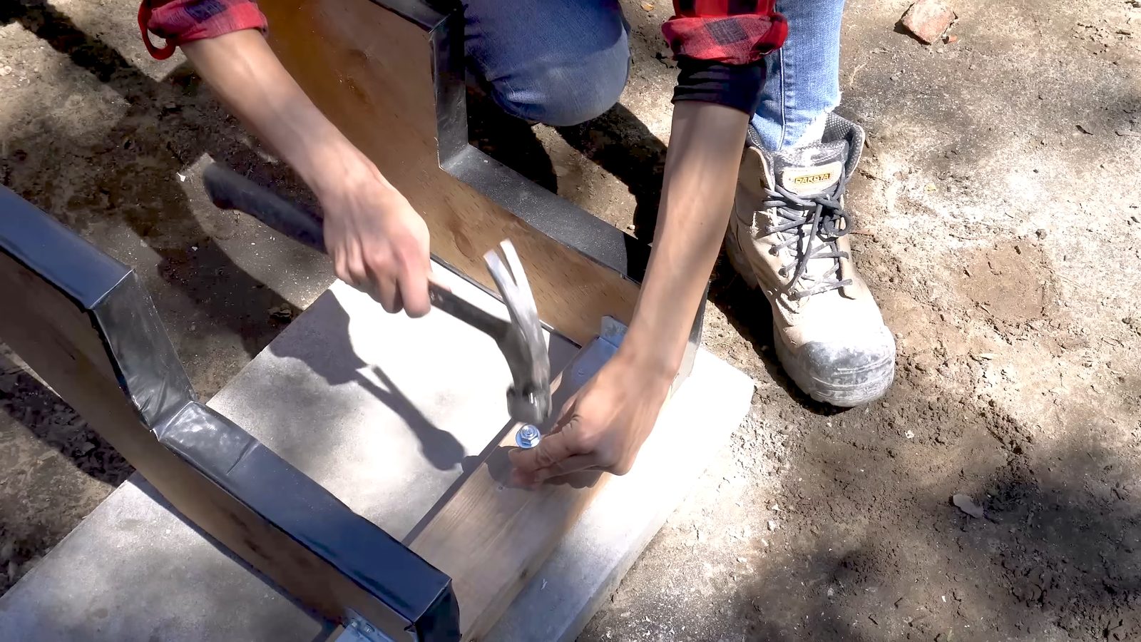 Hammering the masonry wedge anchor into the concrete pad