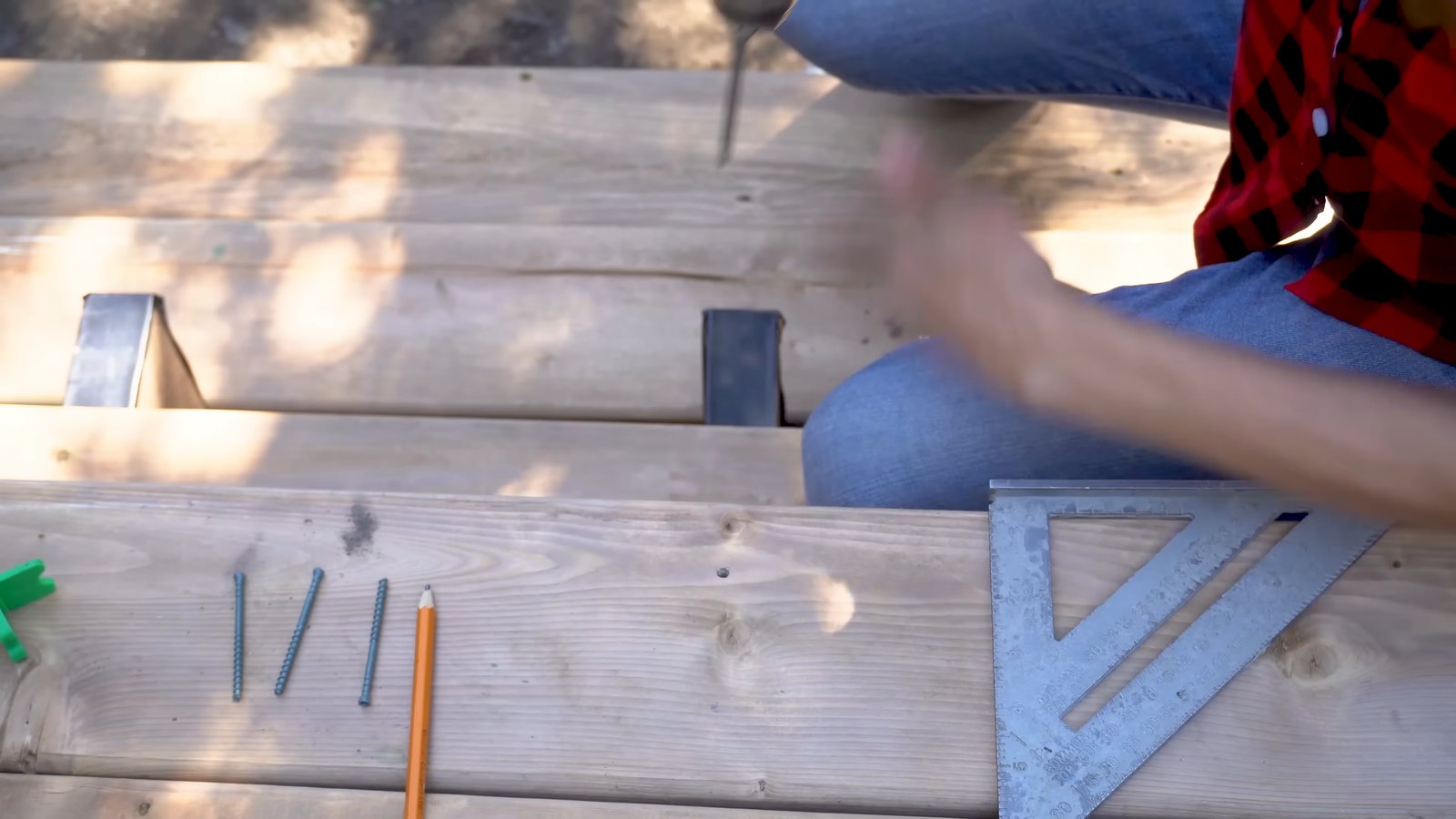 Close-up of GRK FIN Trim head screws on a deck board tread, with a speed square