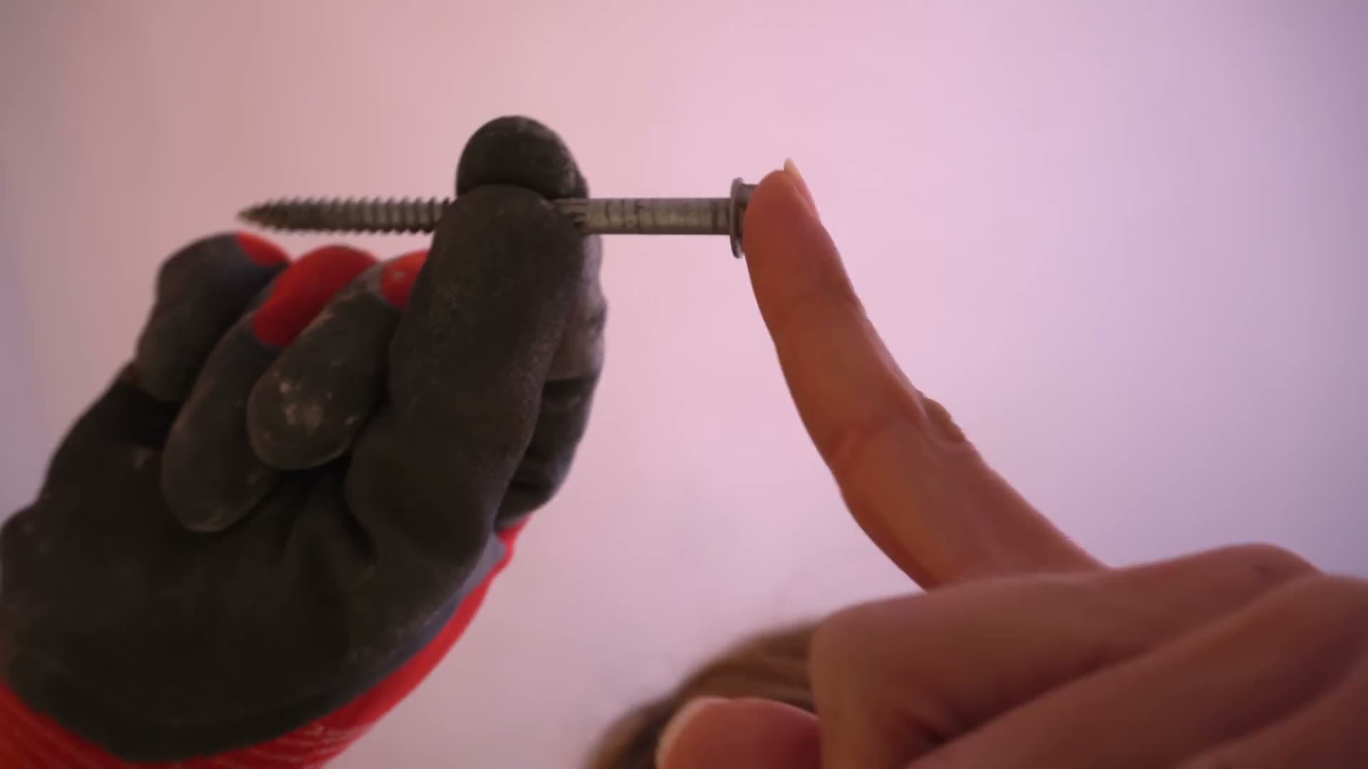 Close-up of a rated structural fastener held in a gloved hand, showing why tile membrane ratings matter