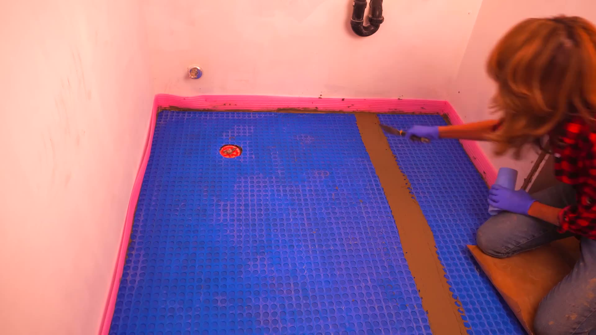 Applying modified mortar over a tile membrane seam before installing waterproofing seam tape