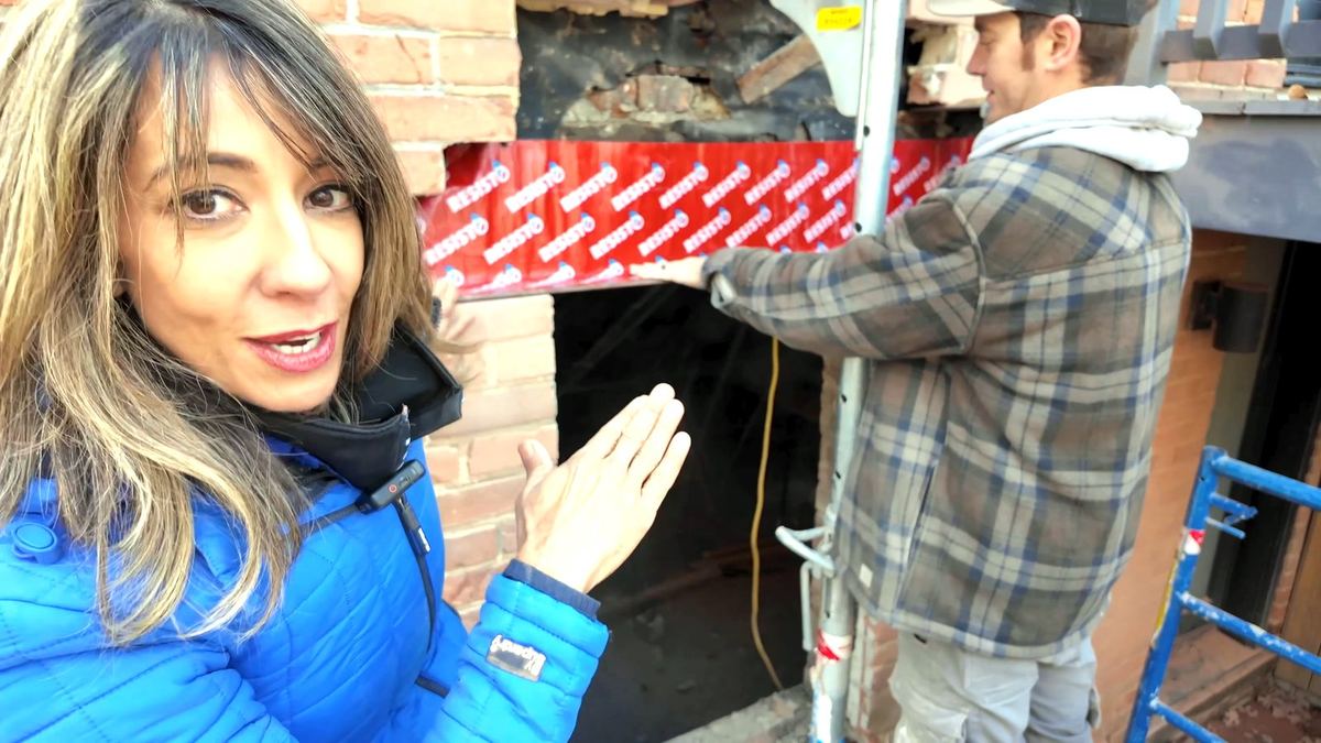 Applying a red waterproofing membrane over a steel lintel