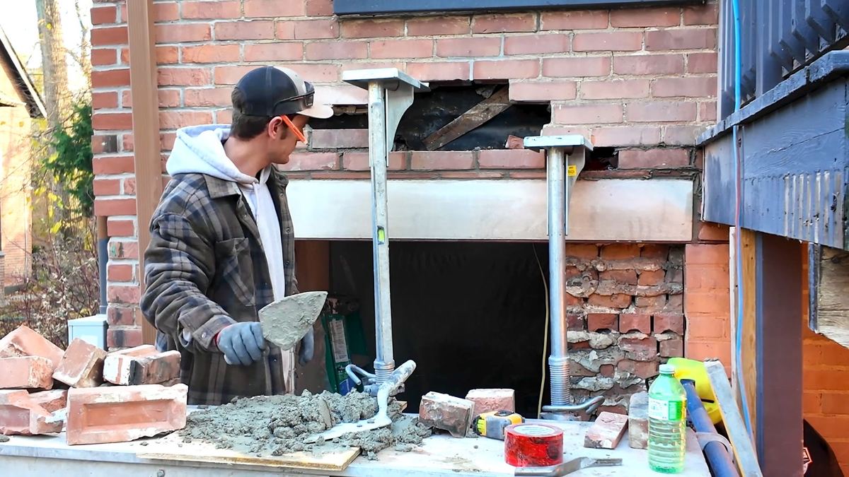 Bricking in around the steel props while they still carry the load