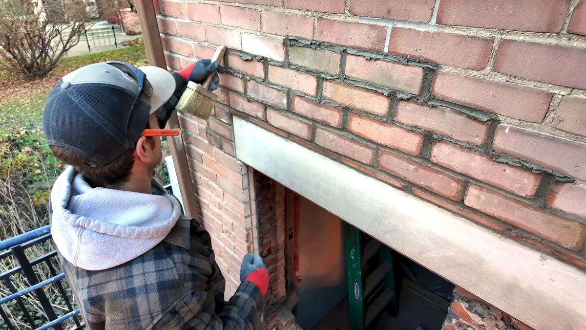 Brushing a fresh mortar joint to weather it and blend with old brickwork