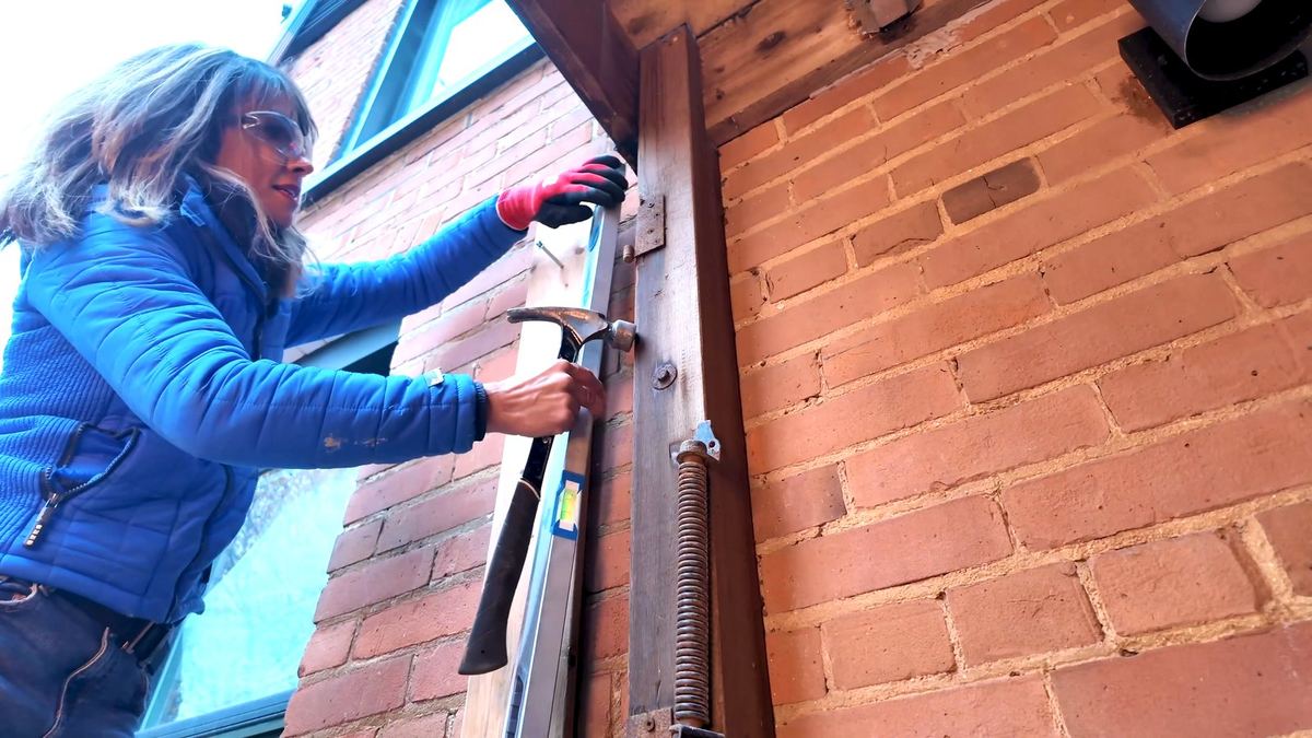 Checking the cut-guide board for plumb with a level before cutting masonry